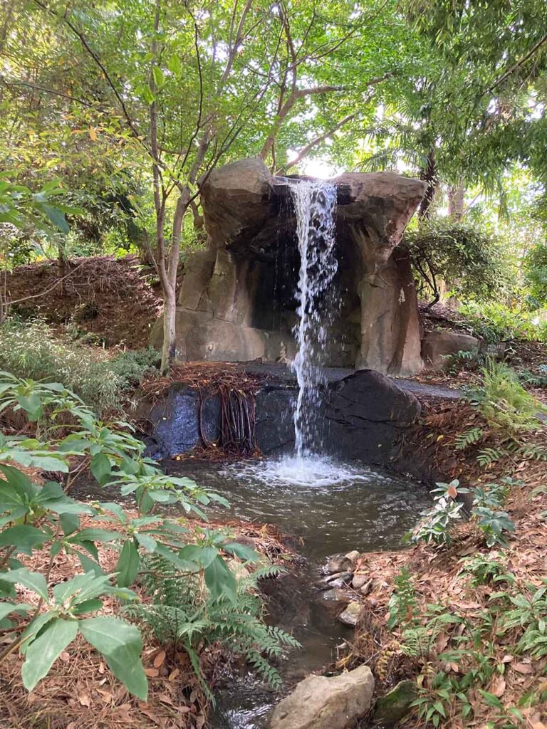 Image of a waterfall off one large rock in the middle of the woods